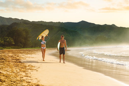 Pareja disfrutando de la playa y las olas, Hawái. SoloCruceros.cl
